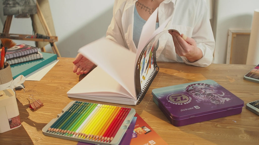Showing how to draw with pencils and paints in a notebook on video